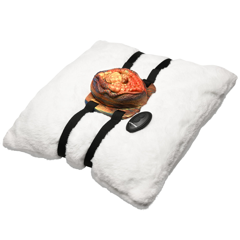 Vibrating silicone grinder with remote control attached to a white pillow.