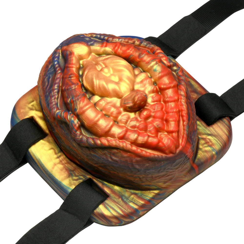 Vibrating silicone grinder with straps in red, gold, and blue.