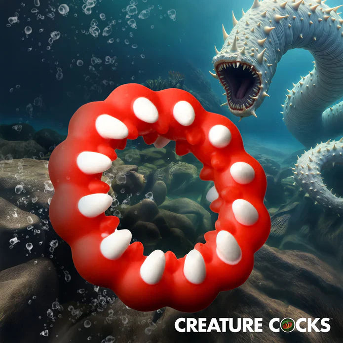 Red silicone cock ring with white fangs and textured bumps.
