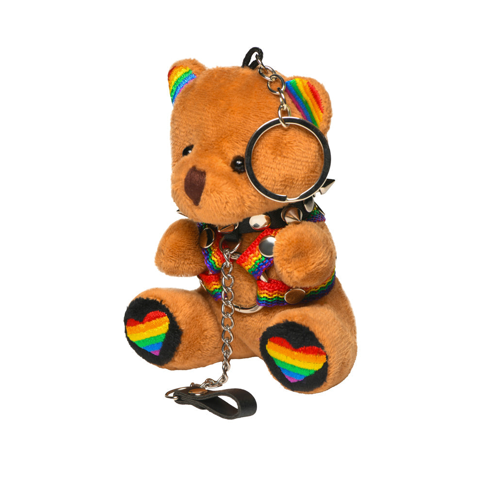 Brown teddy bear keychain with rainbow harness, spiked collar, and rainbow hearts.