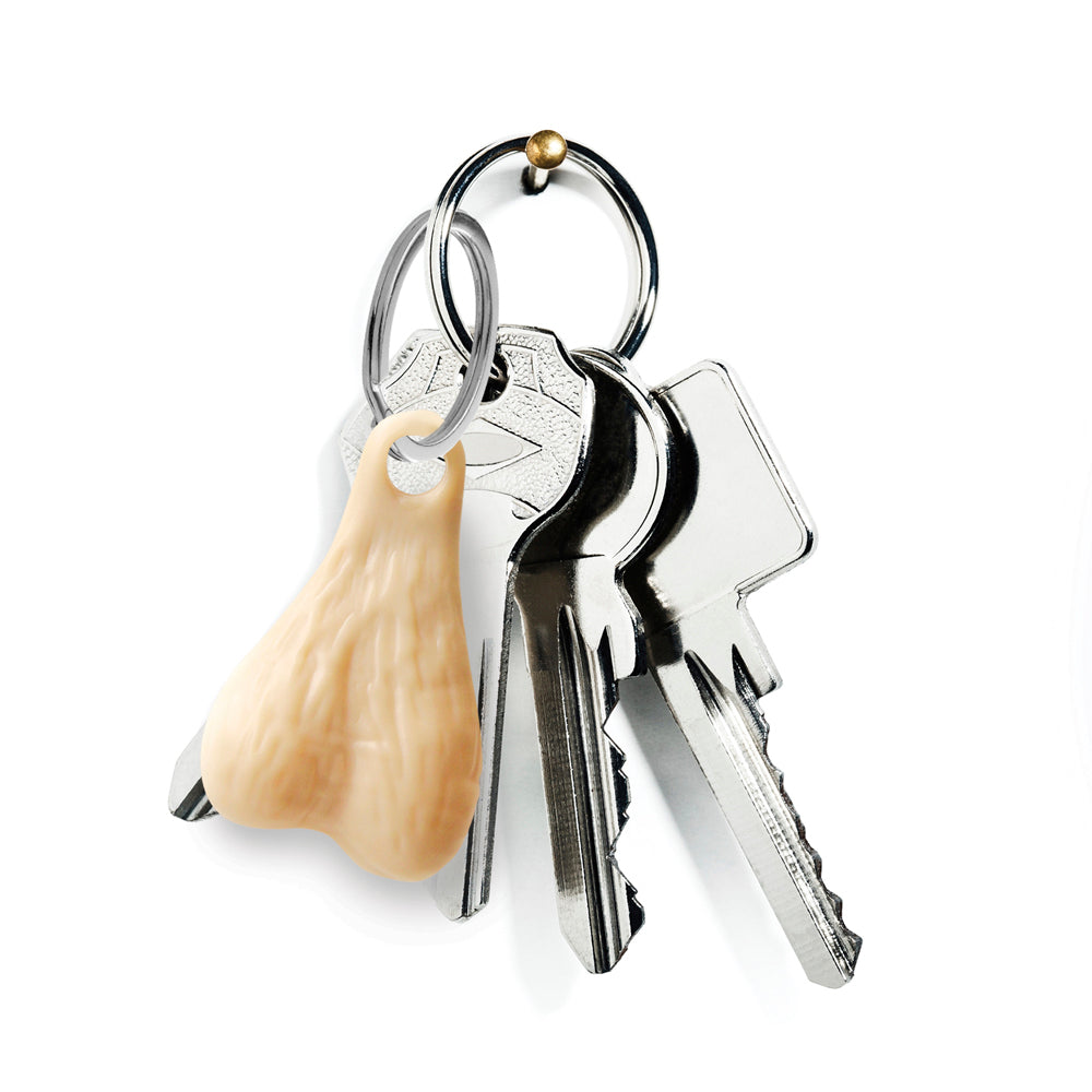 A novelty keychain with a pair of plastic testicles hangs from a hook with keys.