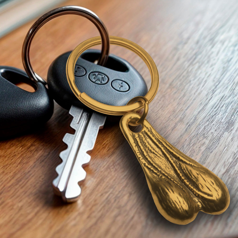 Brass novelty keychain shaped like testicles attached to a car key.