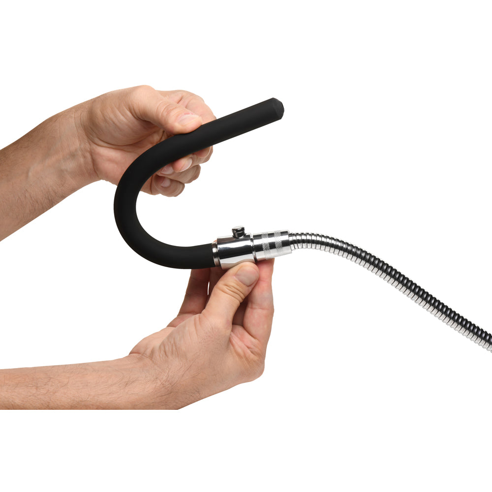 Hands hold a black silicone enema nozzle attached to a flexible metal shower hose.