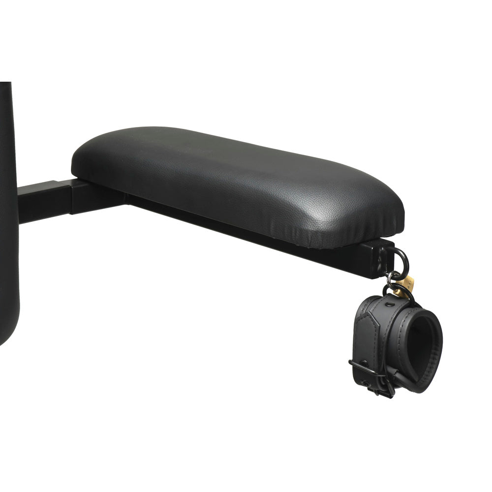 Black leather restraint cuff attached to a padded armrest on a chair.