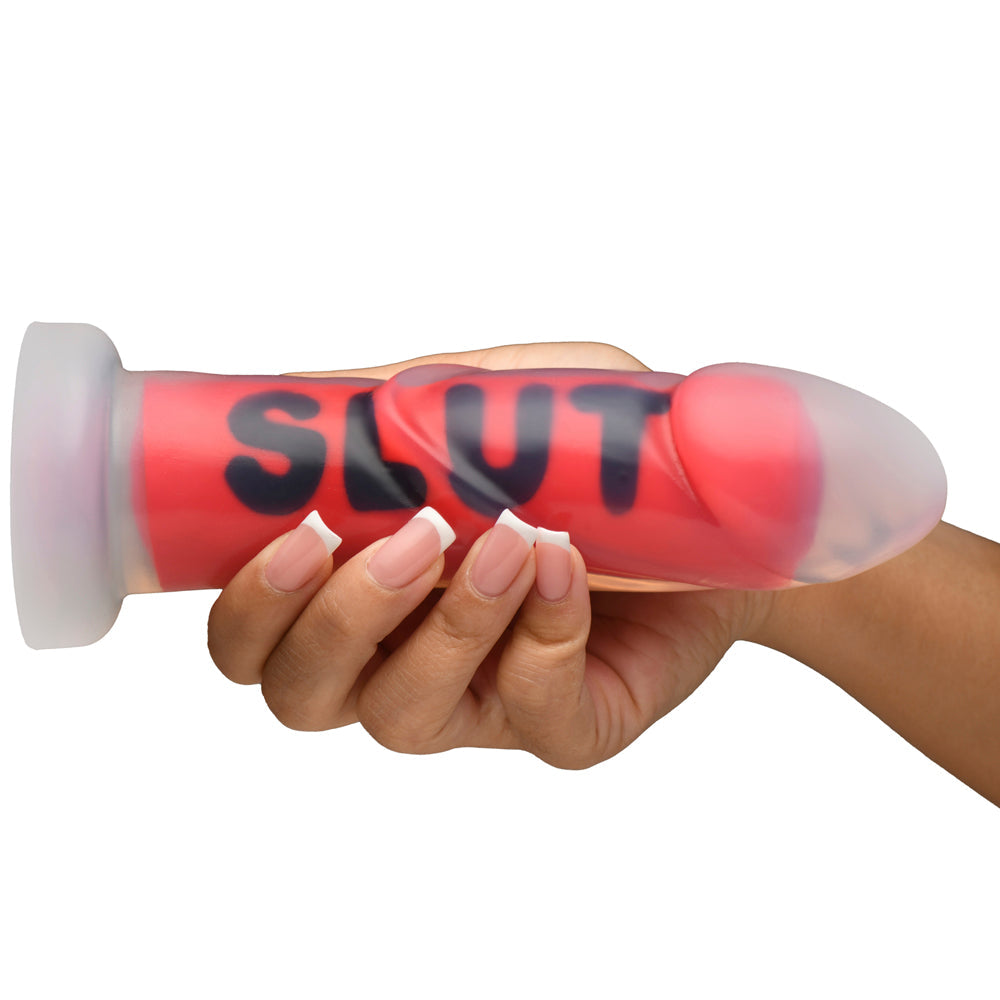 A red silicone dildo with black lettering and a clear suction cup base.