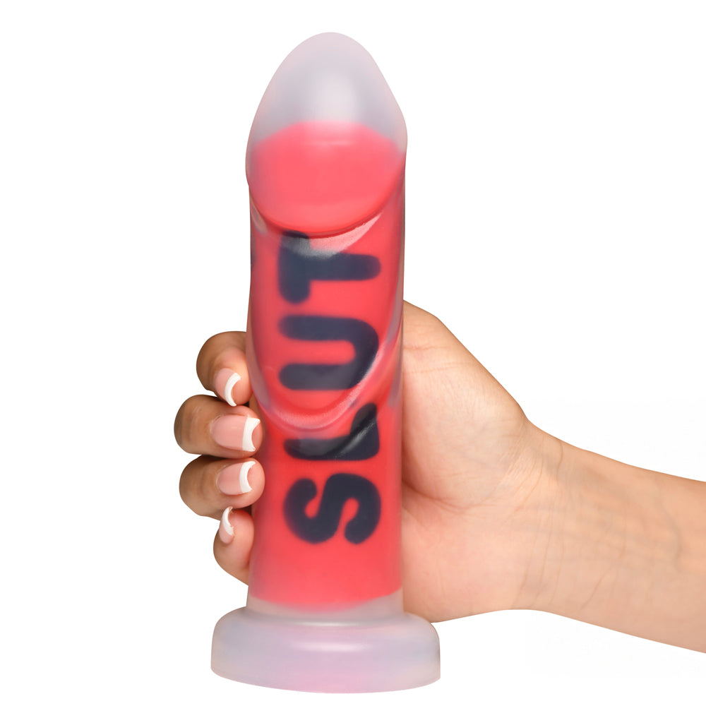 A red ribbed dildo with black lettering held by a hand.