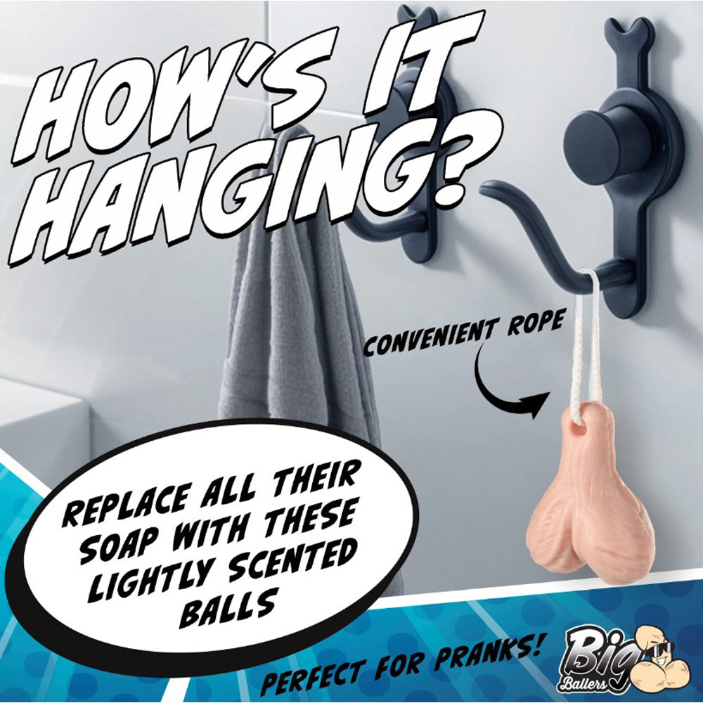 A novelty soap shaped like testicles hangs from a rope on a shower hook.