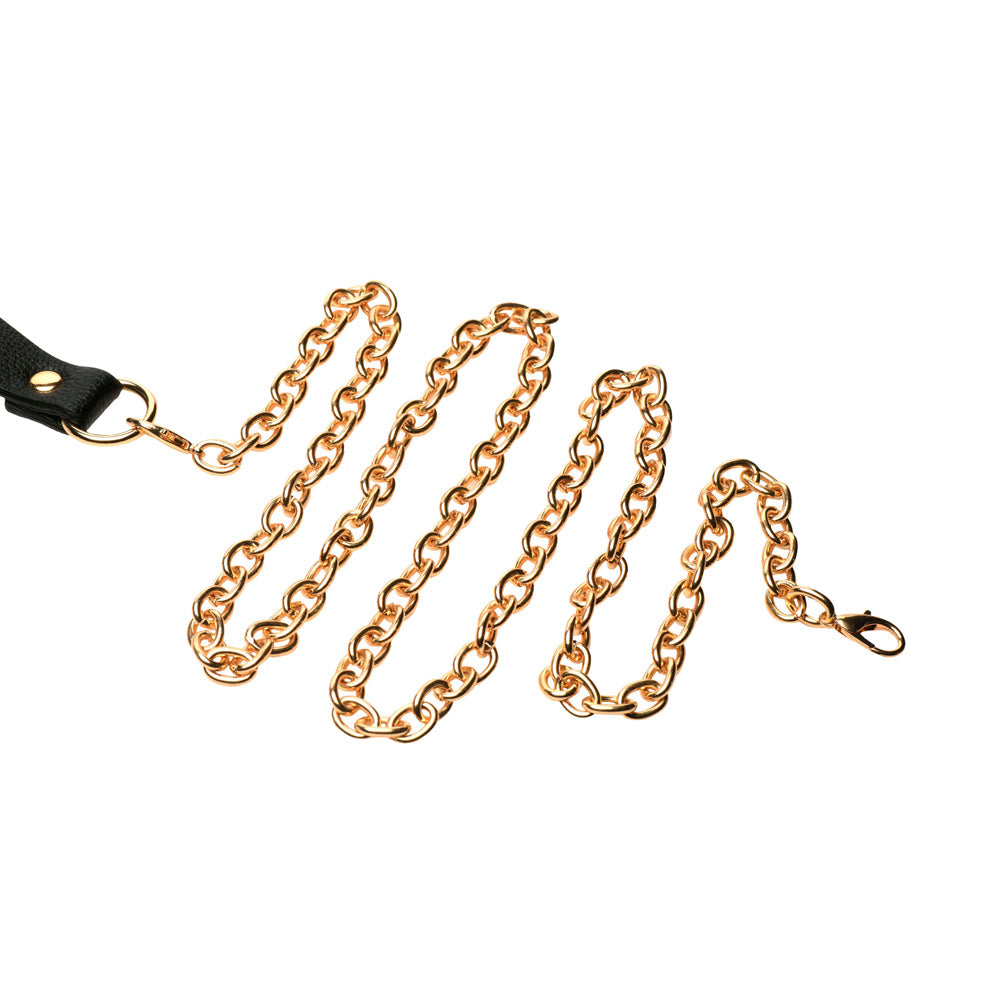 Gold chain leash attached to a black vegan leather collar.