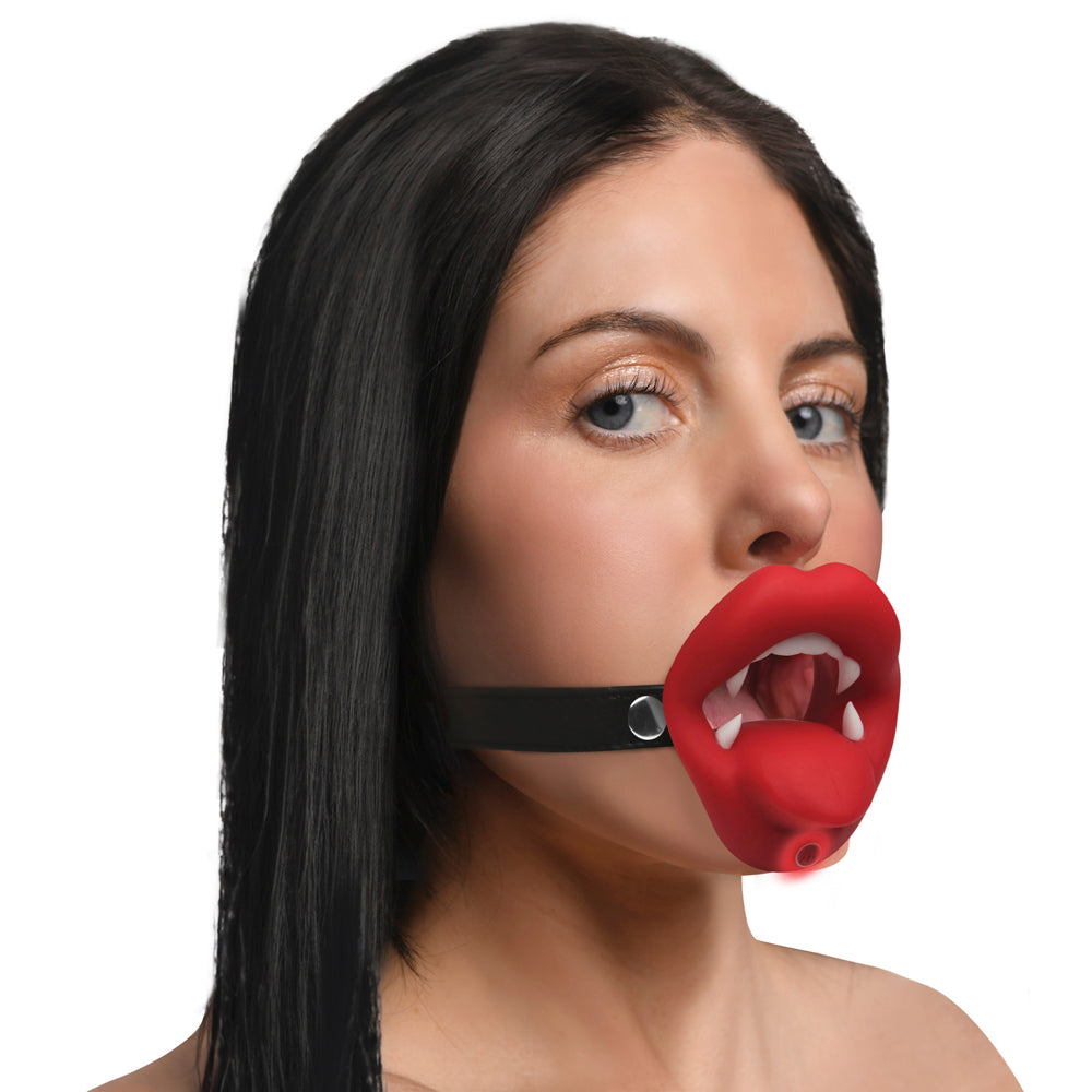 Vibrating vampire mouth gag with red lips and fangs on a black strap.