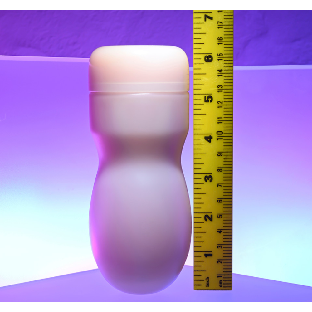 A textured pocket stroker with a beige cap and a yellow ruler for scale.