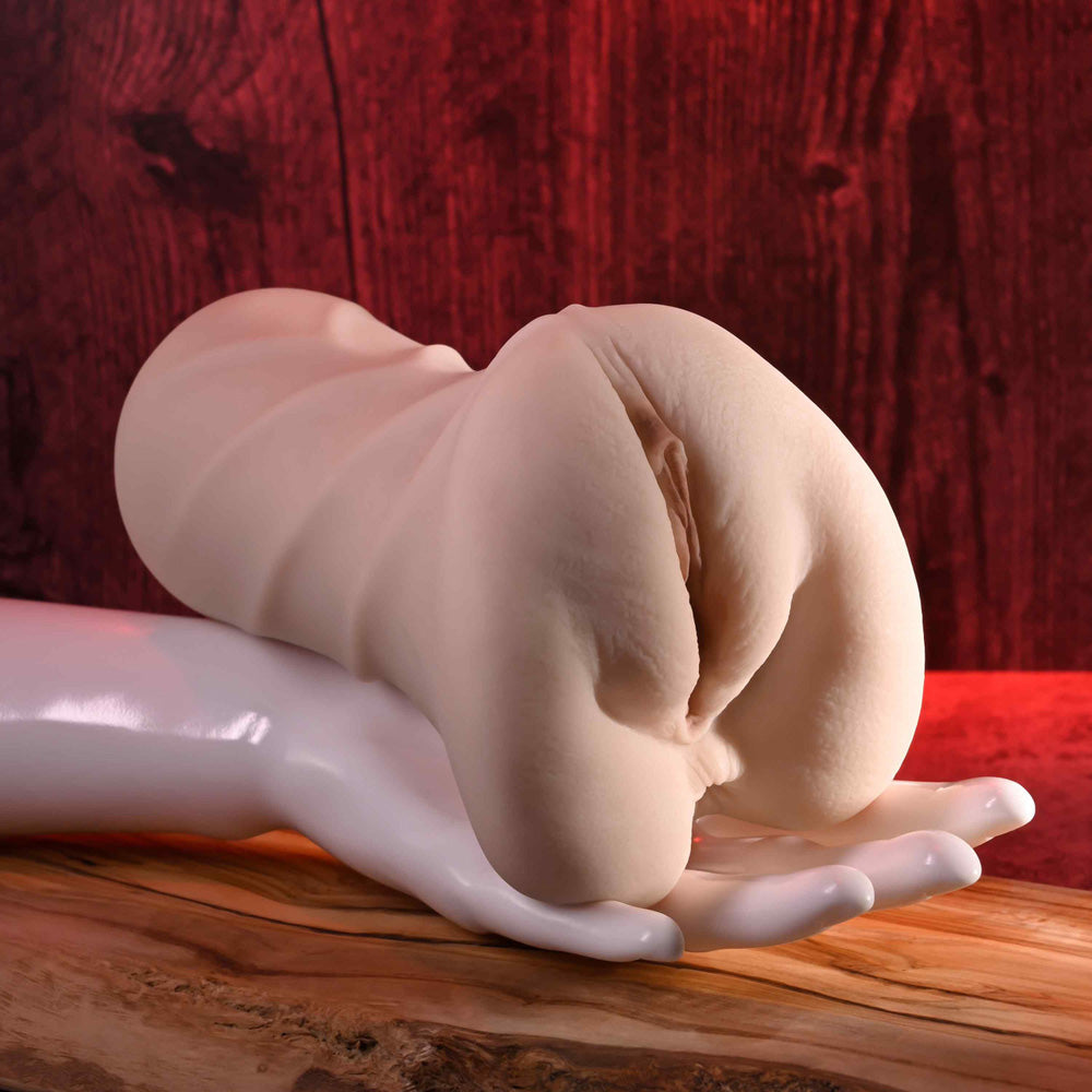 Riley Reid dual entry stroker in white TPE on a red wood background with white hand and clear canister.