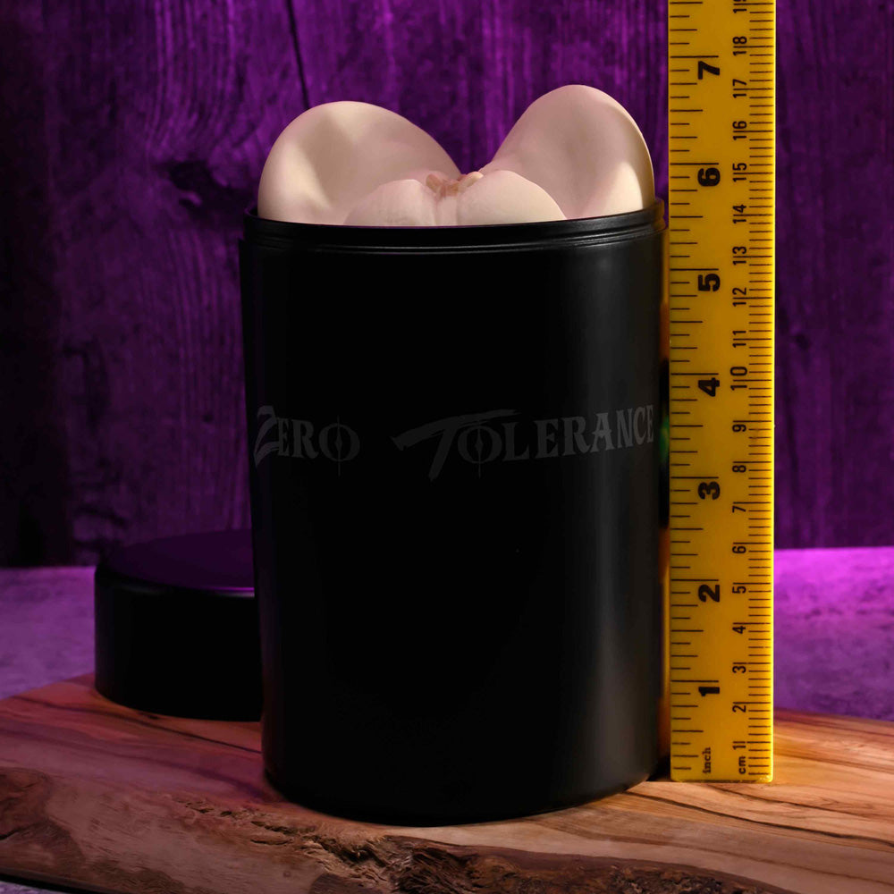 Black dual-entry stroker in waterproof canister, 7 inches tall, on wooden surface.