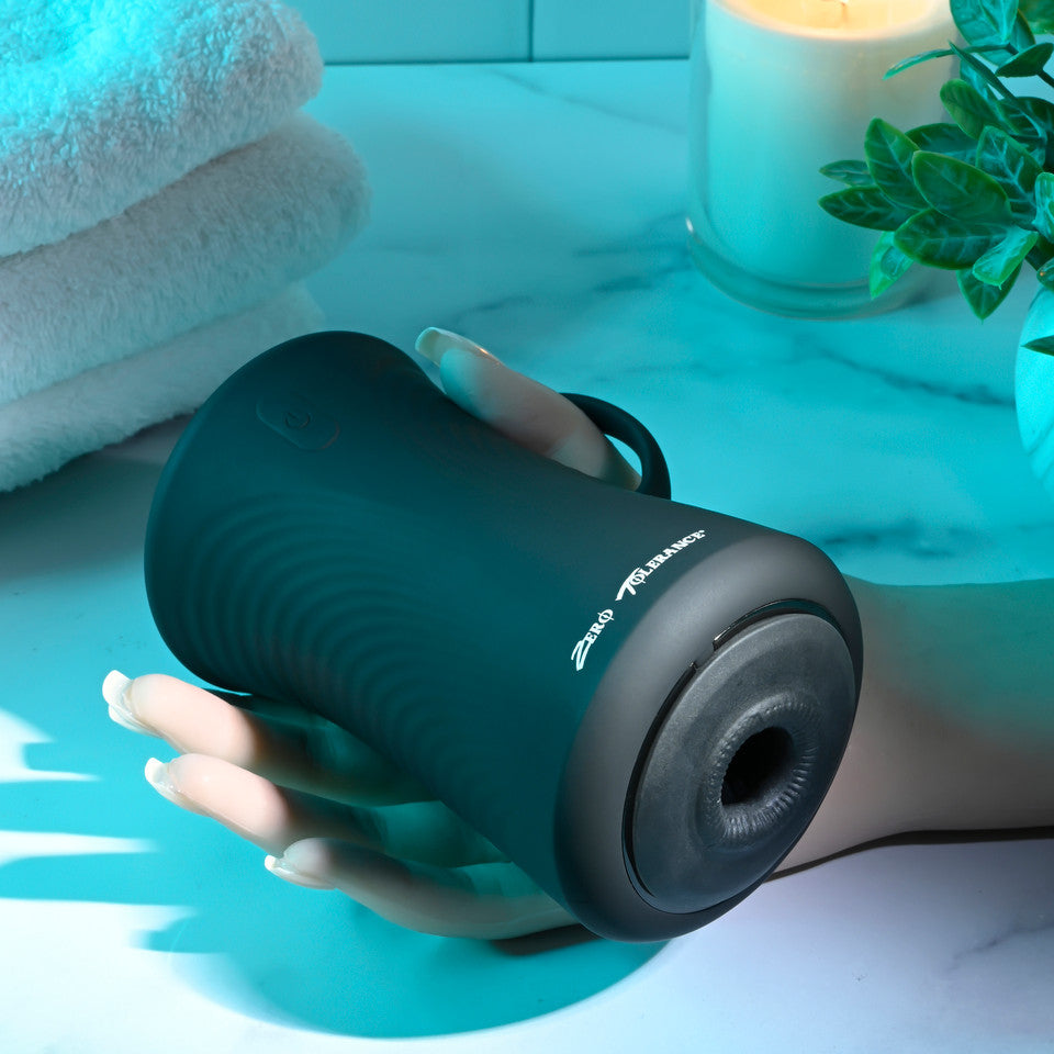 A black gyrating ball stroker with "Zero Tolerance" text held by a hand.