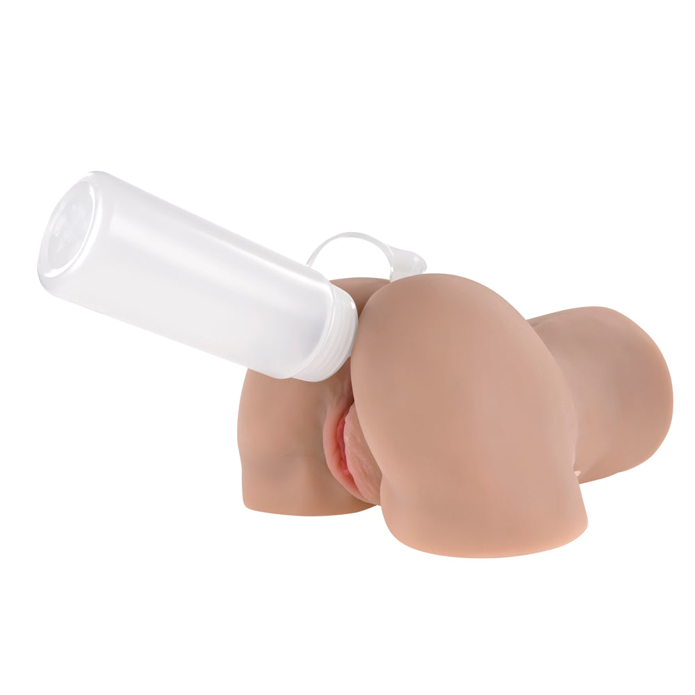 Realistic brown silicone butt with white lube bottle on top, showing vaginal and anal openings.