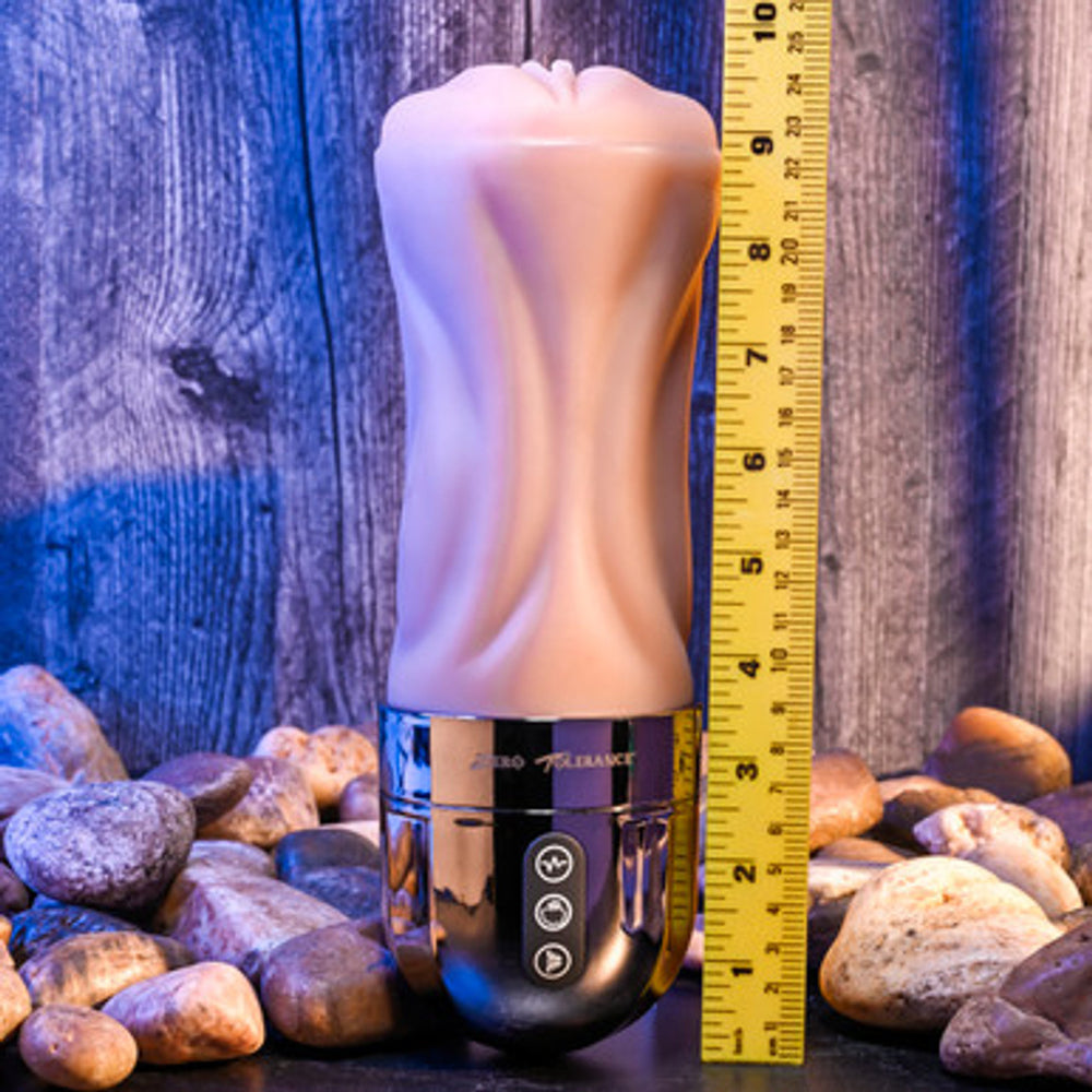 A ribbed, flesh-toned stroker with a metallic base and a ruler for scale.