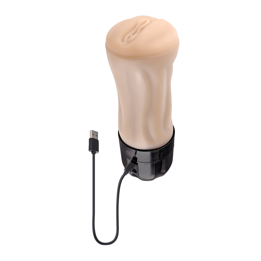 A flesh-toned vibrating stroker with a black base and USB charging cable.
