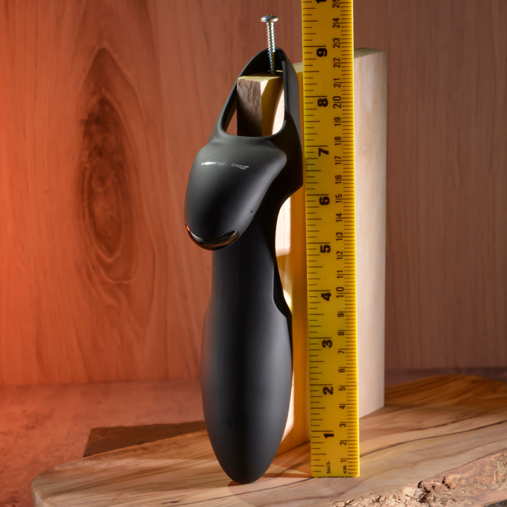 Black vibrating sleeve with remote control, measured against a ruler.