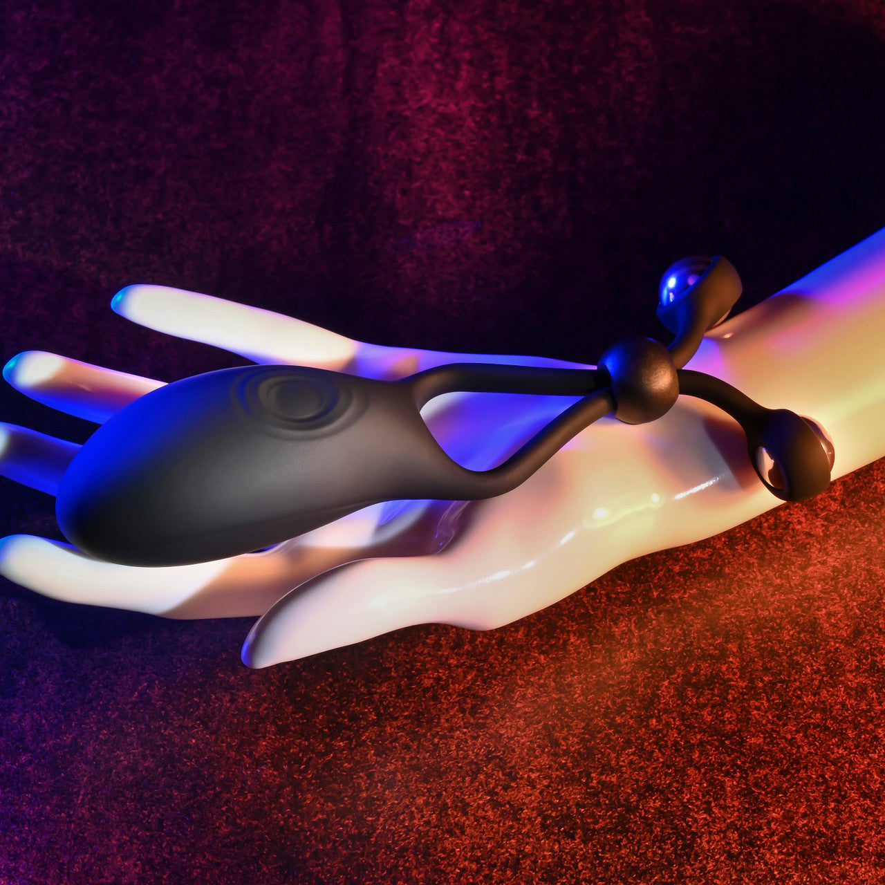 Black cock ring with steel balls on a mannequin hand.