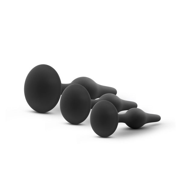Three black silicone anal plugs of graduated sizes.