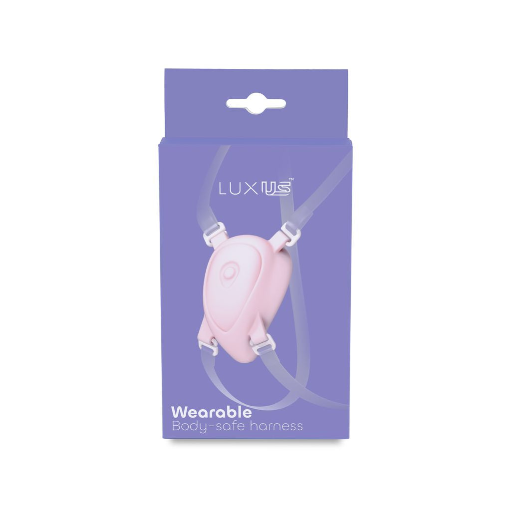 Pink wearable body-safe harness with straps and the Luxus logo.