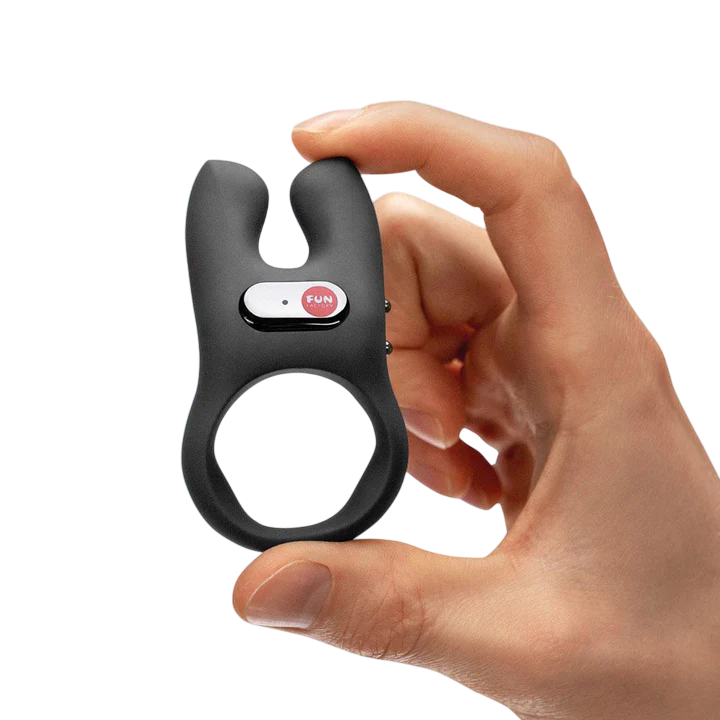 A black dual-pronged vibrator with a "FUN" button held in a hand.