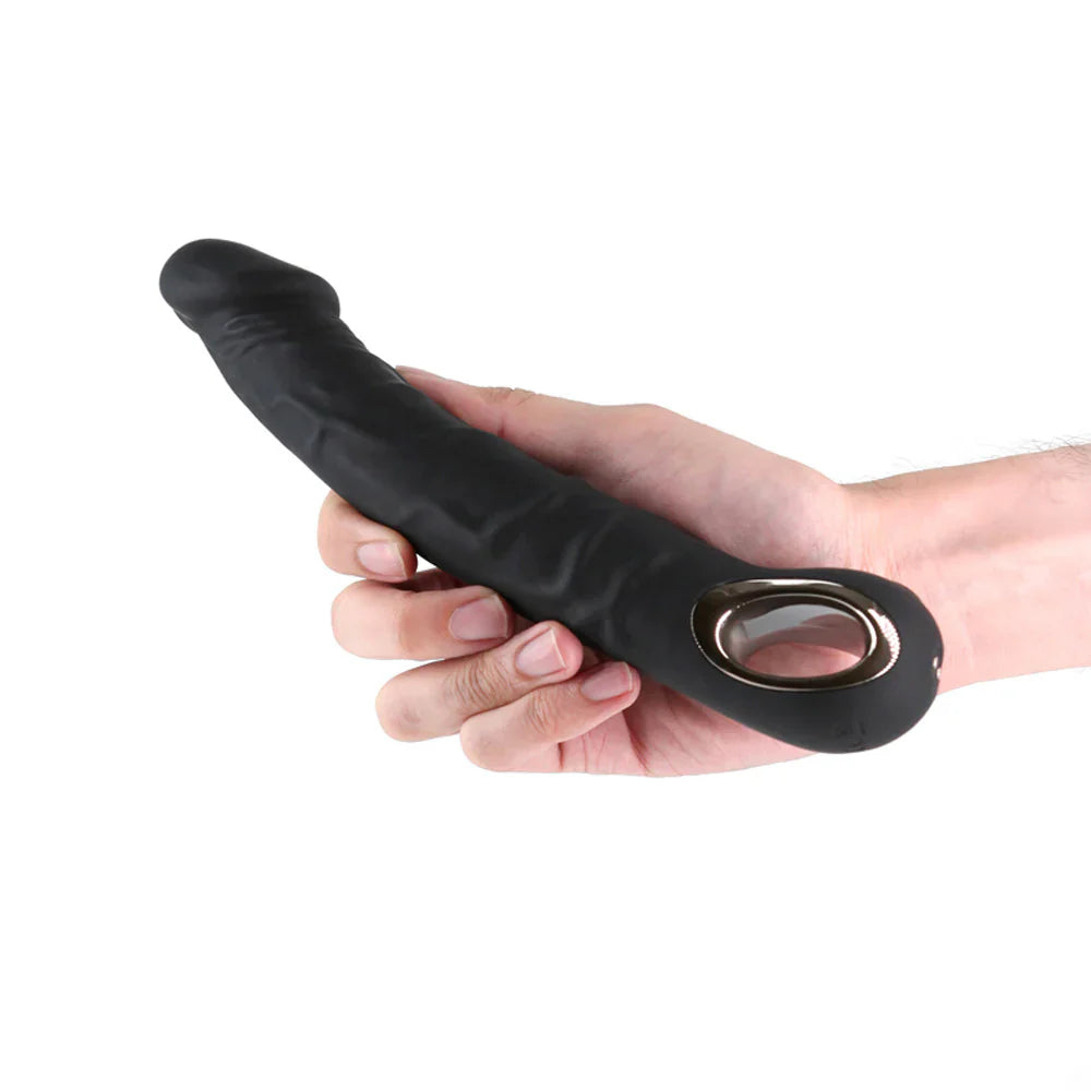 A black flexible silicone vibrator with a metal ring held in a hand.