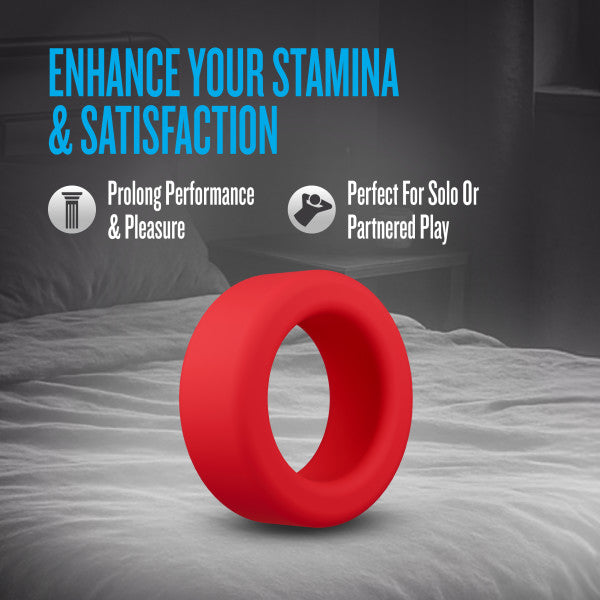 A red silicone cock ring on a bed.