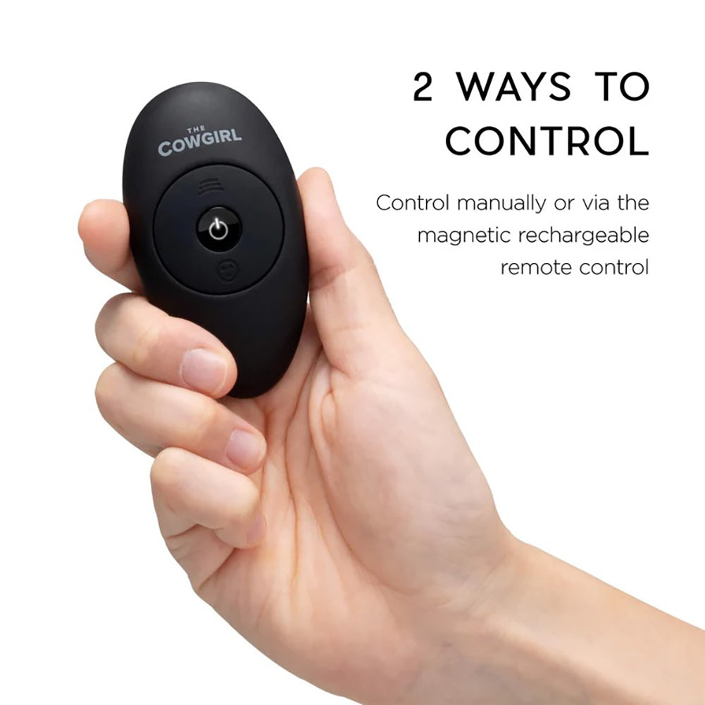 A hand holds a black remote control with "The Cowgirl" logo.