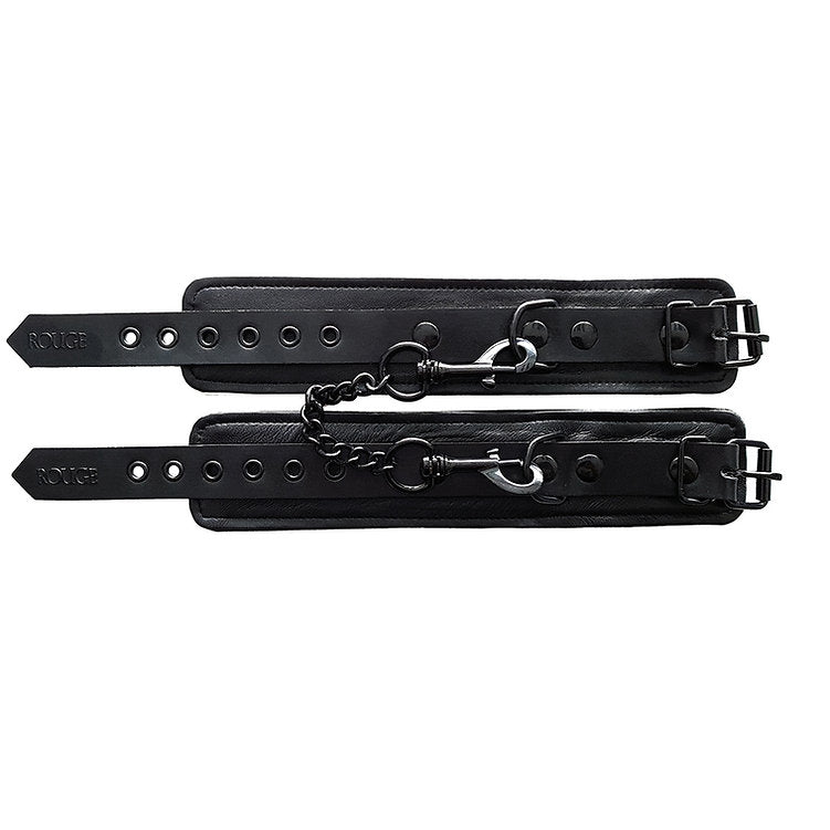 Black leather wrist cuffs with adjustable straps and a connecting chain.
