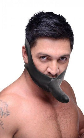 Latex face harness with a black dildo attached.
