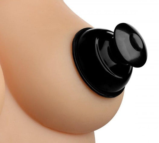 Black silicone nipple suckers attached to a flesh-toned surface.