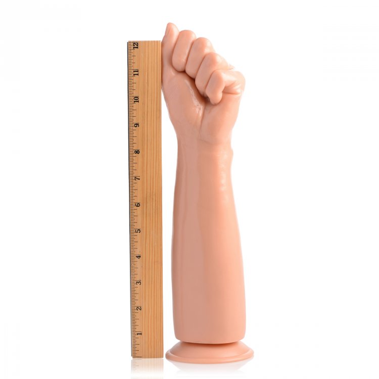 A flesh-colored, realistic clenched fist dildo with a ruler for scale.