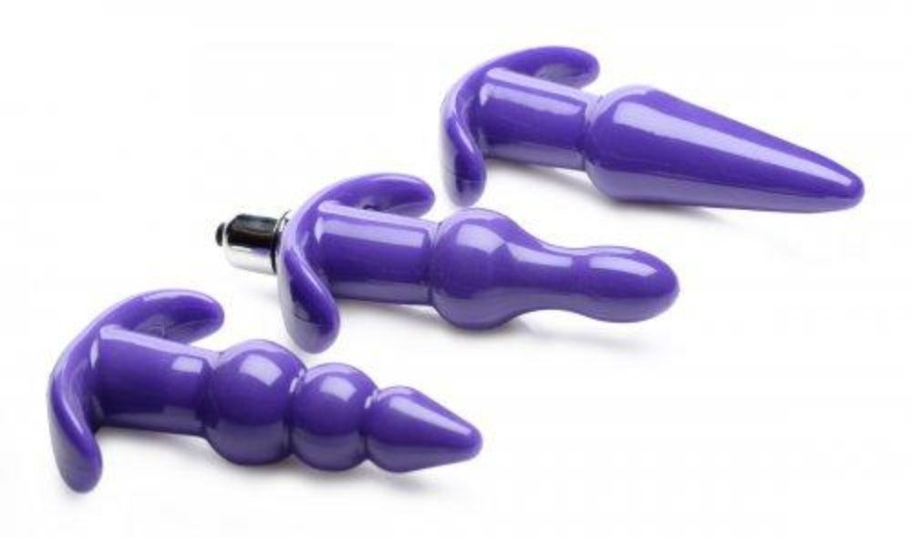 Three purple anal plugs with different shapes and a vibrating bullet.