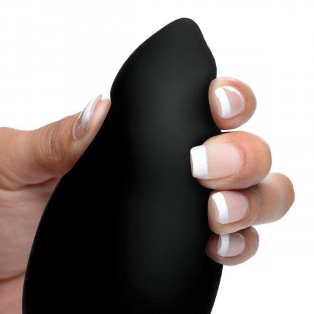 A hand holds a black tapered vibrating anal plug.