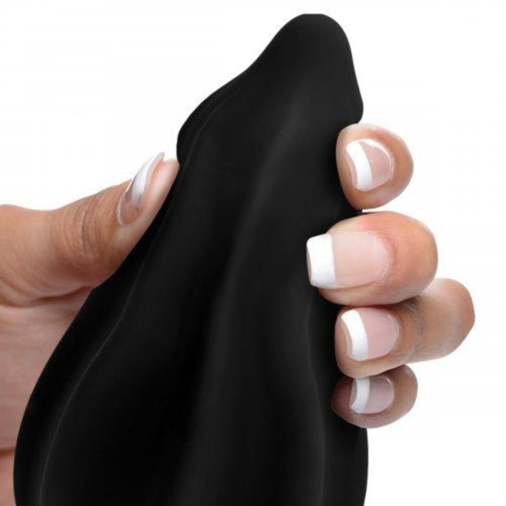 A hand holds a black ribbed vibrating anal plug.