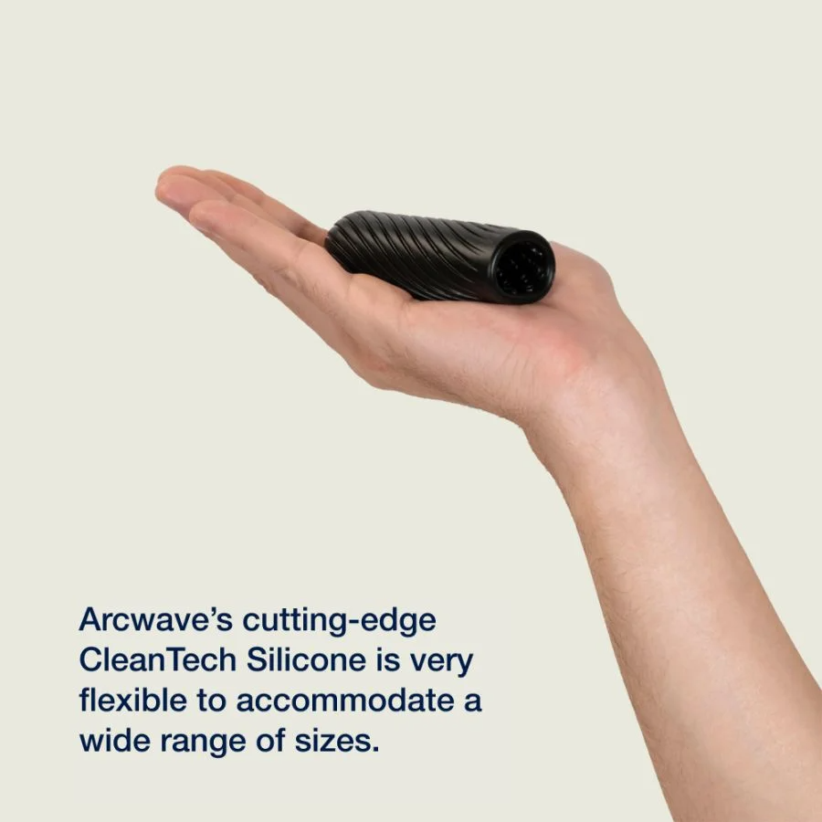 A black, textured silicone stroker rests in an open palm.