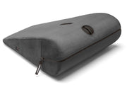A black velvish positioning pillow with a zipper and a handle.