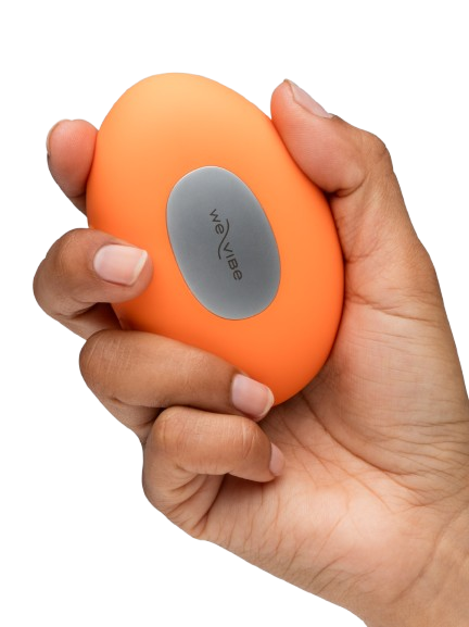 An orange We-Vibe vibrator with a gray oval button is held in a hand.