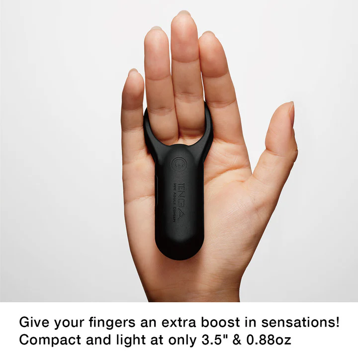 A black Tenga vibrating cock ring is worn on a person's fingers.