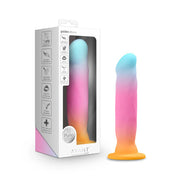 A gradient pink, blue, and orange silicone stimulator with a suction cup base.