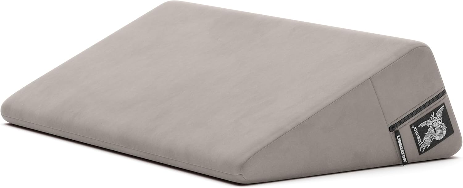 Grey velvet wedge positioning pillow with a zipper and logo.