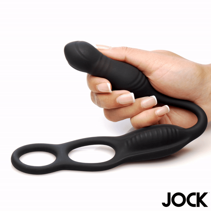 Black silicone remote thrusting anal plug with C-ring and ribbed taint stimulator, held in hand.