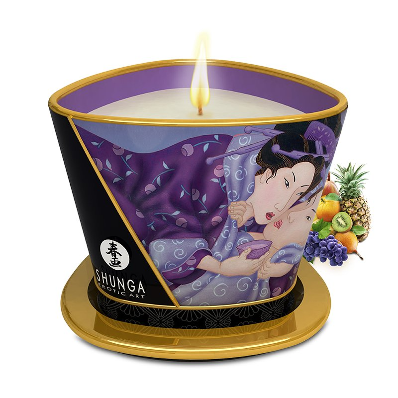 A Shunga massage candle with exotic fruit imagery and a lit wick.