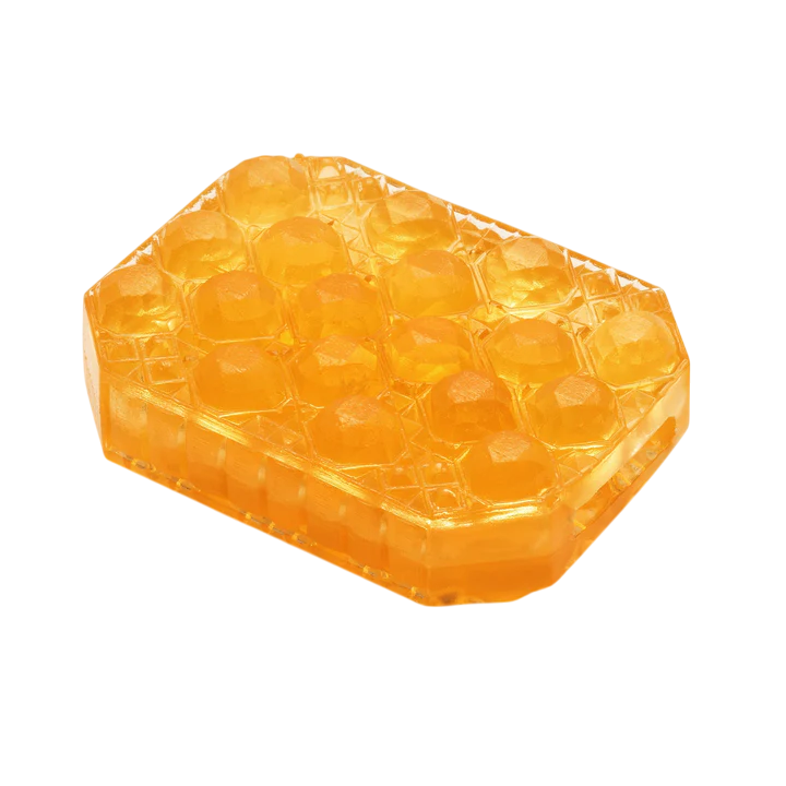 A translucent orange honeycomb-shaped object with a textured surface.