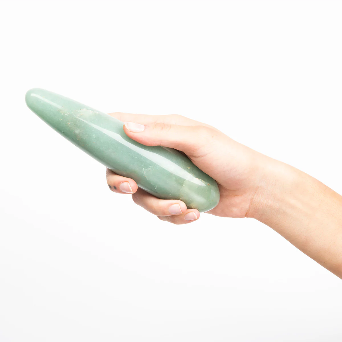 A hand holds a smooth, green aventurine crystal wand.