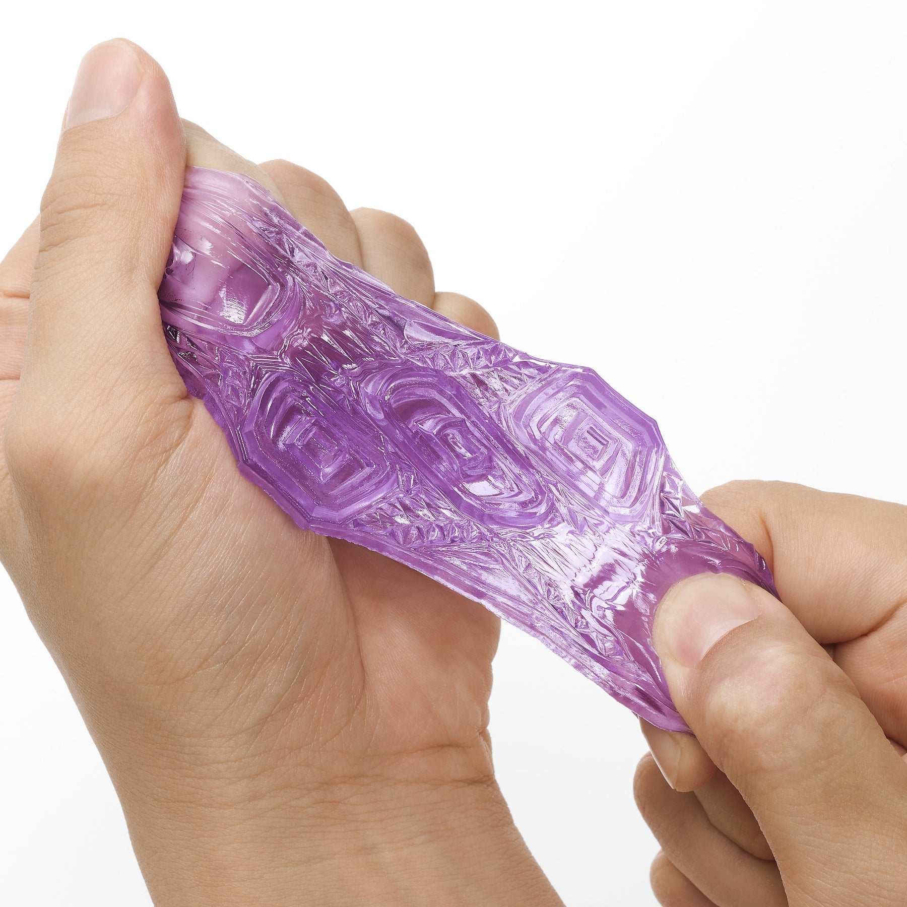 Hands hold a purple, textured pleasure sleeve.