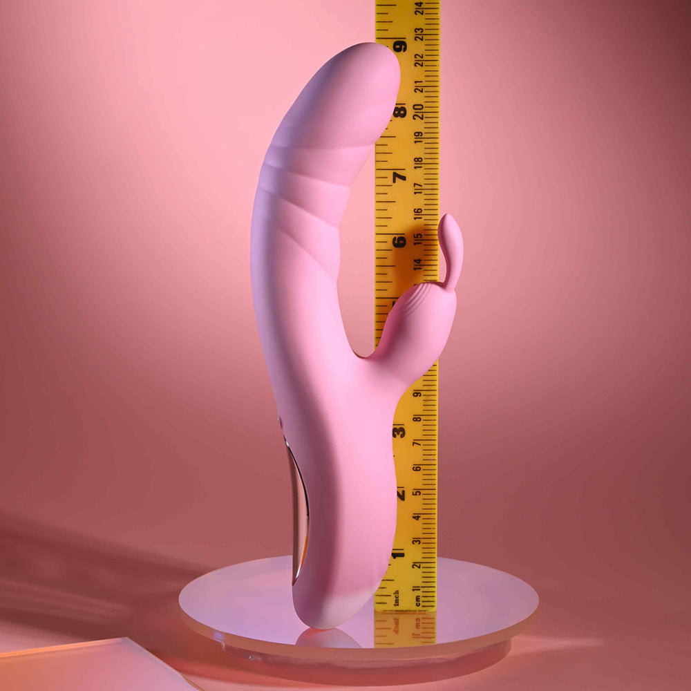 A pink rabbit vibrator is measured against a ruler.