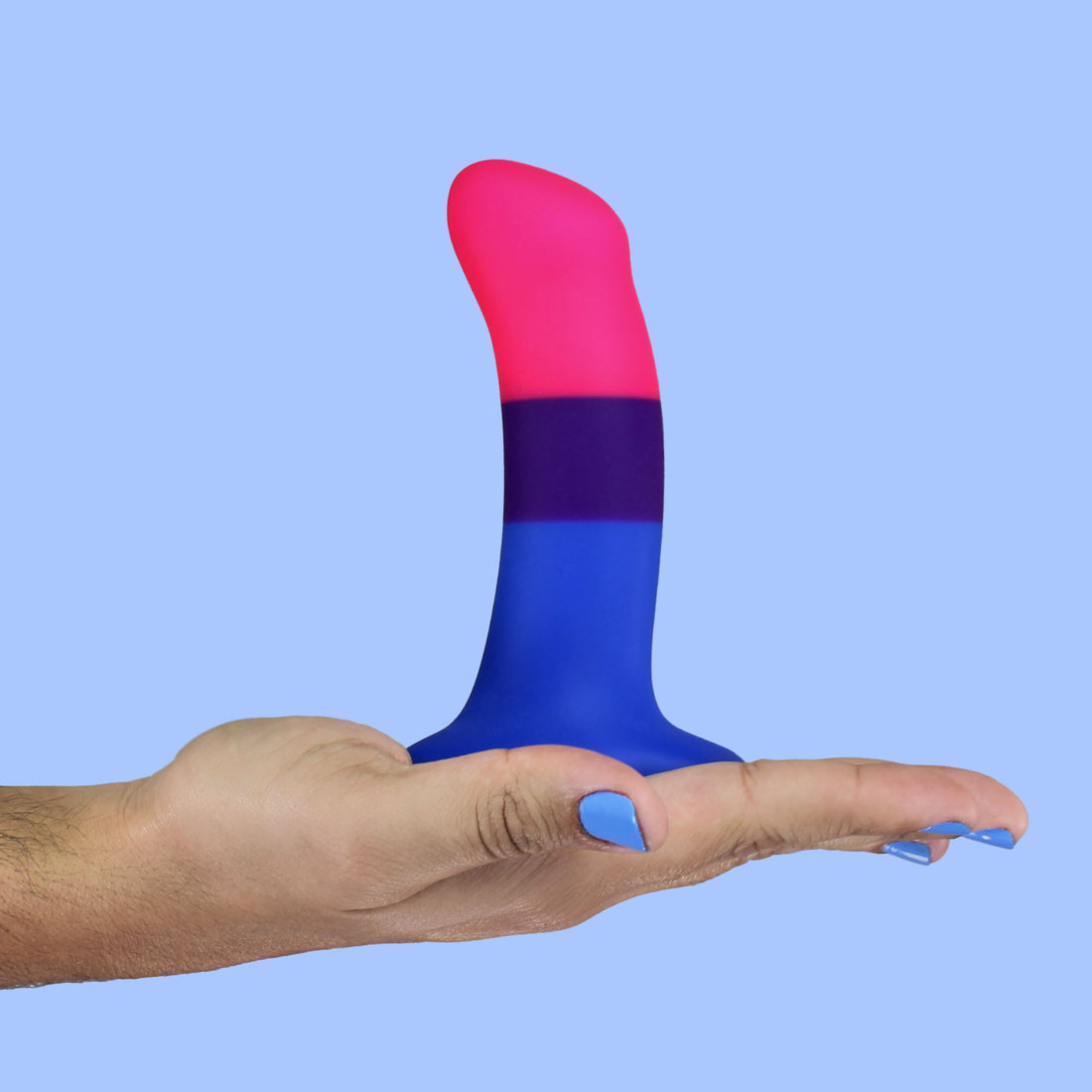 A bisexual pride dildo with pink, purple, and blue stripes held in a hand.