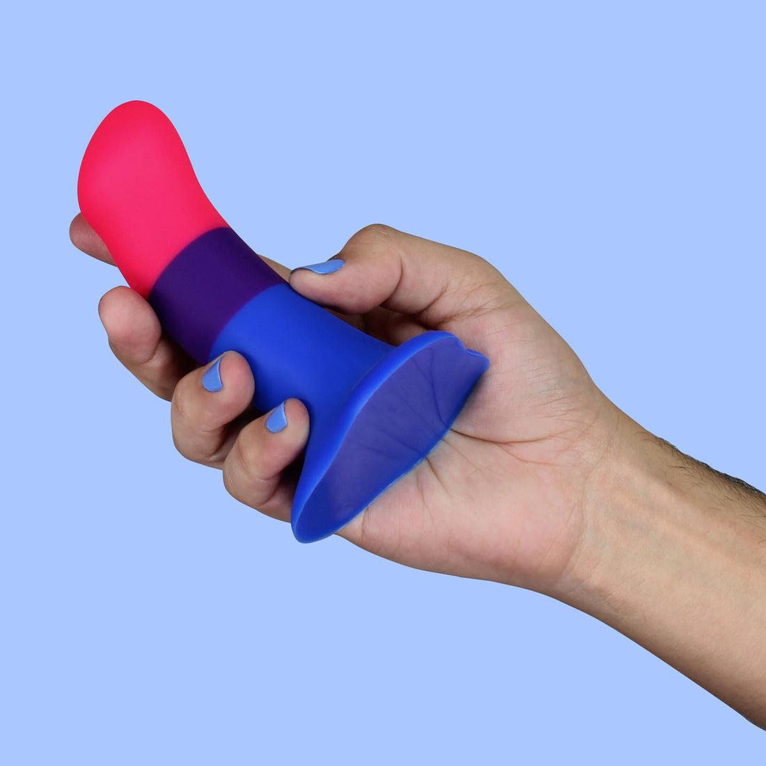 A hand holds a bisexual pride colored dildo with a flared base.