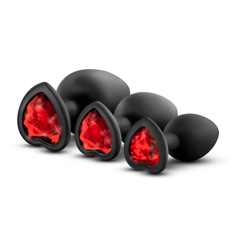 Black silicone anal plugs with red heart gems in progressive sizes.